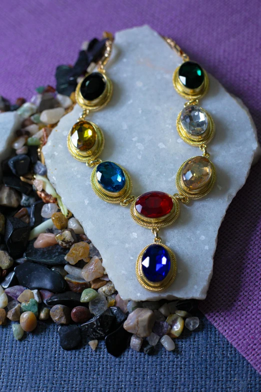 a necklace is set on a rock by rocks