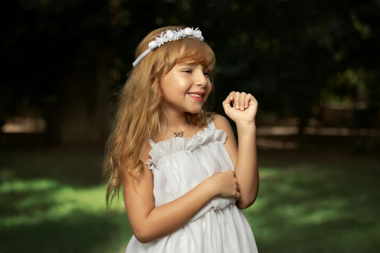 a little girl smiling with a white flower in her hair