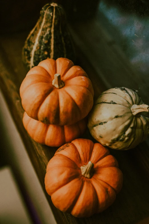 a group of pumpkins on a wooden table