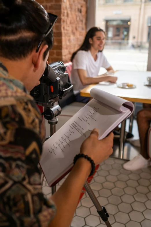 a camera and some people sitting at a table