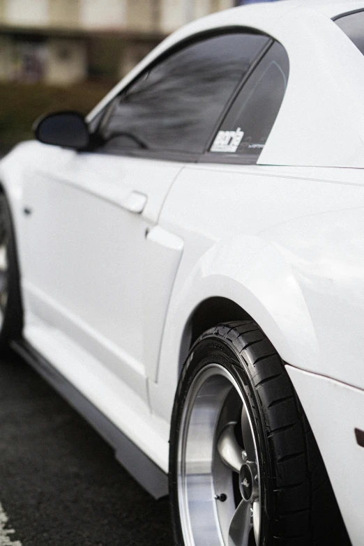 white car parked on the street with no tires