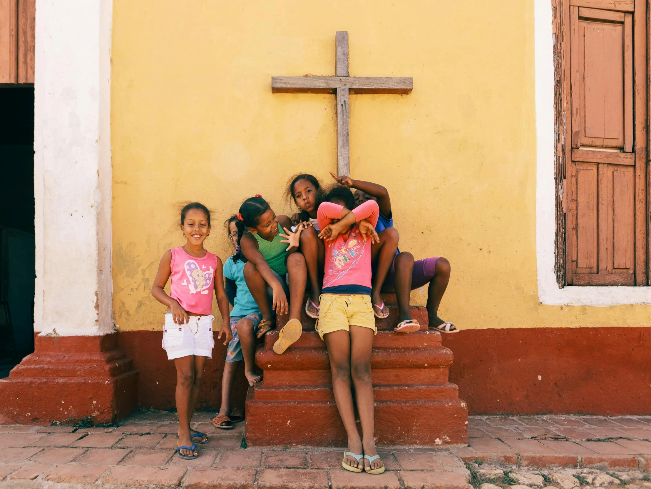 four little girls are standing on a step and posing