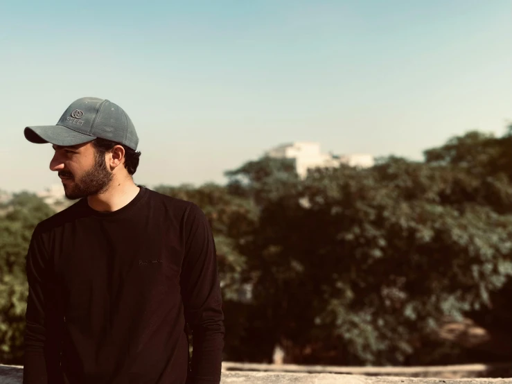 a man wearing a black hat, a black shirt and jeans