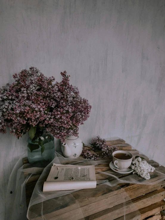a book on the side table with flowers