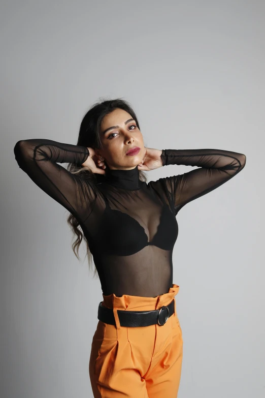 a girl in orange pants and a sheer top