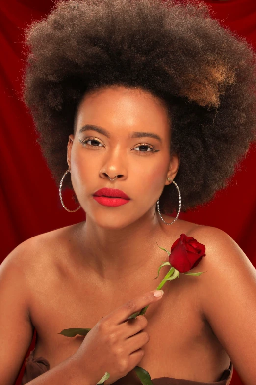 a woman in a black dress with a red rose in her hand