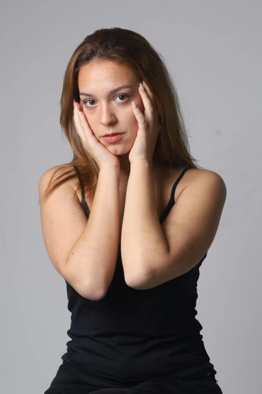 a woman posing with her hands on her face