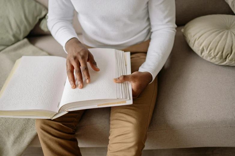 person sitting on a couch holding a book