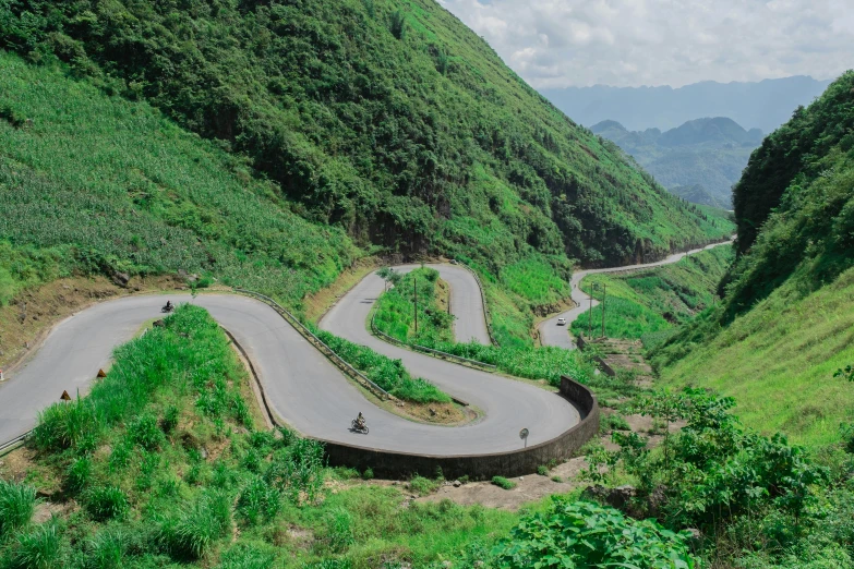 a person is riding on a bicycle down a long winding road