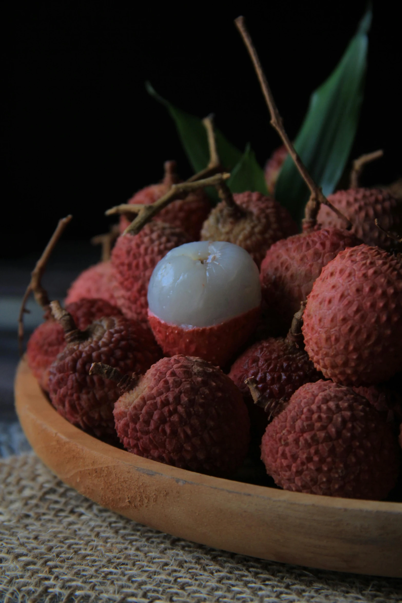 a wooden bowl filled with round red fruit