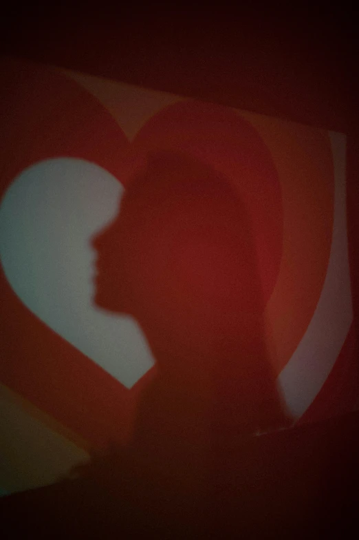 silhouetted image of person with red shadow on the back ground