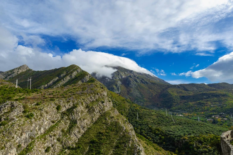 mountains with green trees on each side under blue sky