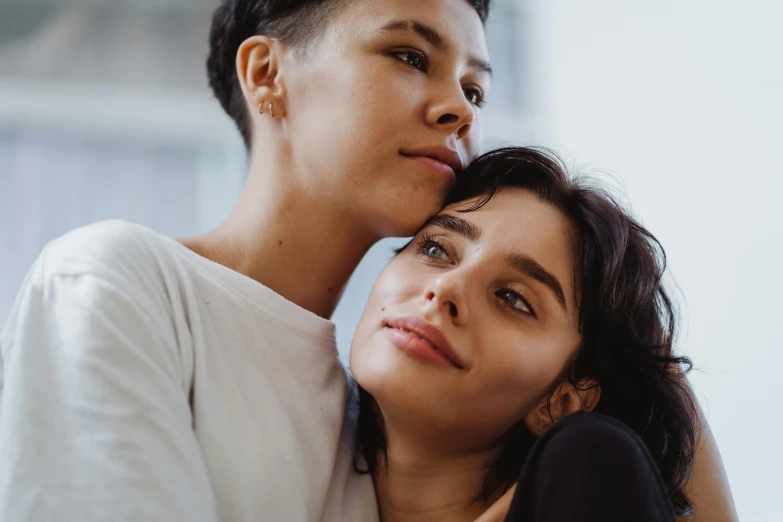 two woman staring at the camera and one of them is leaning on her head