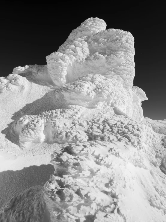 a snow covered mountain slope with the sky in background