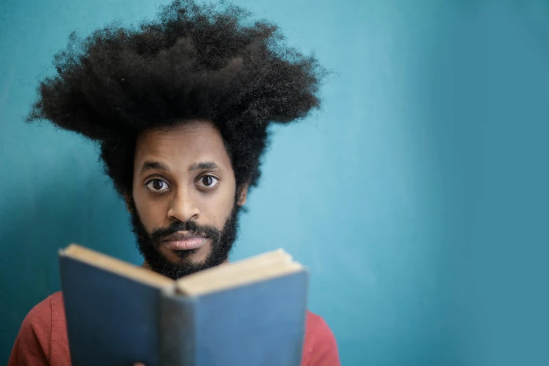 an indian man with black hair reading a book