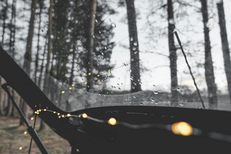 the view from inside a car is of lights shining in the rain