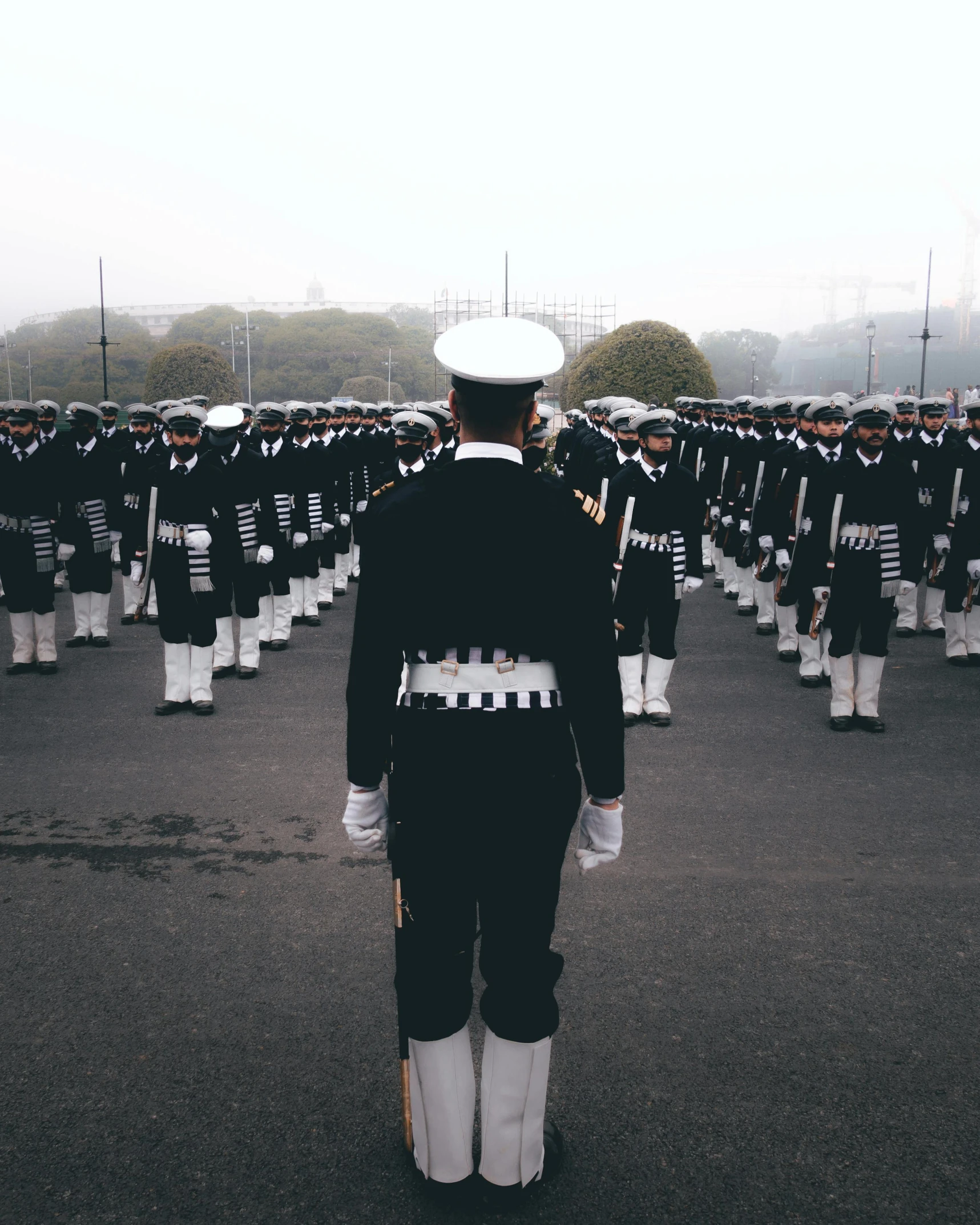 a parade with uniforms and hats on in the street