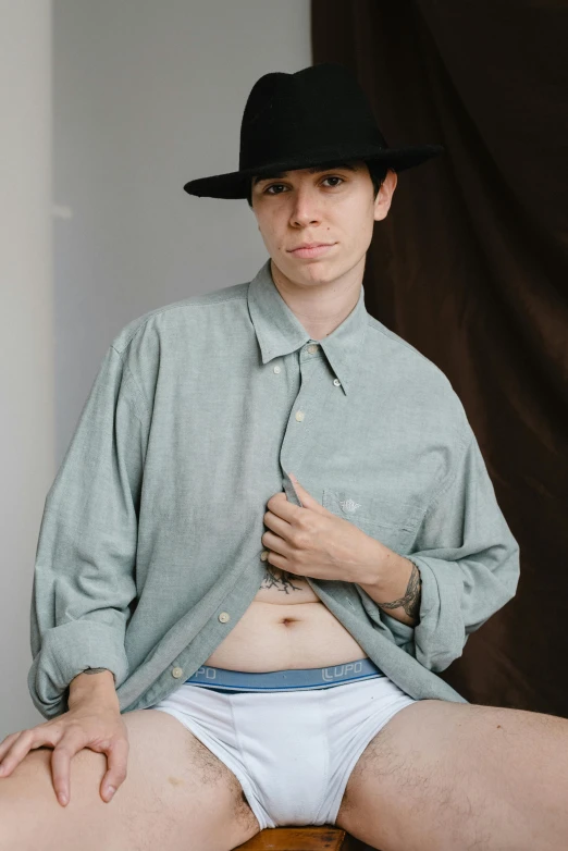 a person in underwear wearing a hat poses