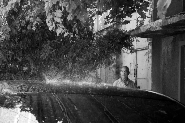 a black and white po of a man taking a picture from the street