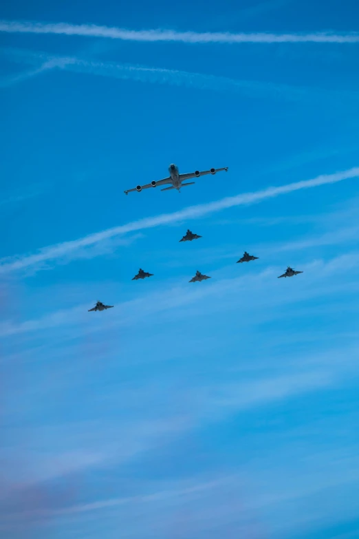 an airplane in a formation with other planes flying in the sky