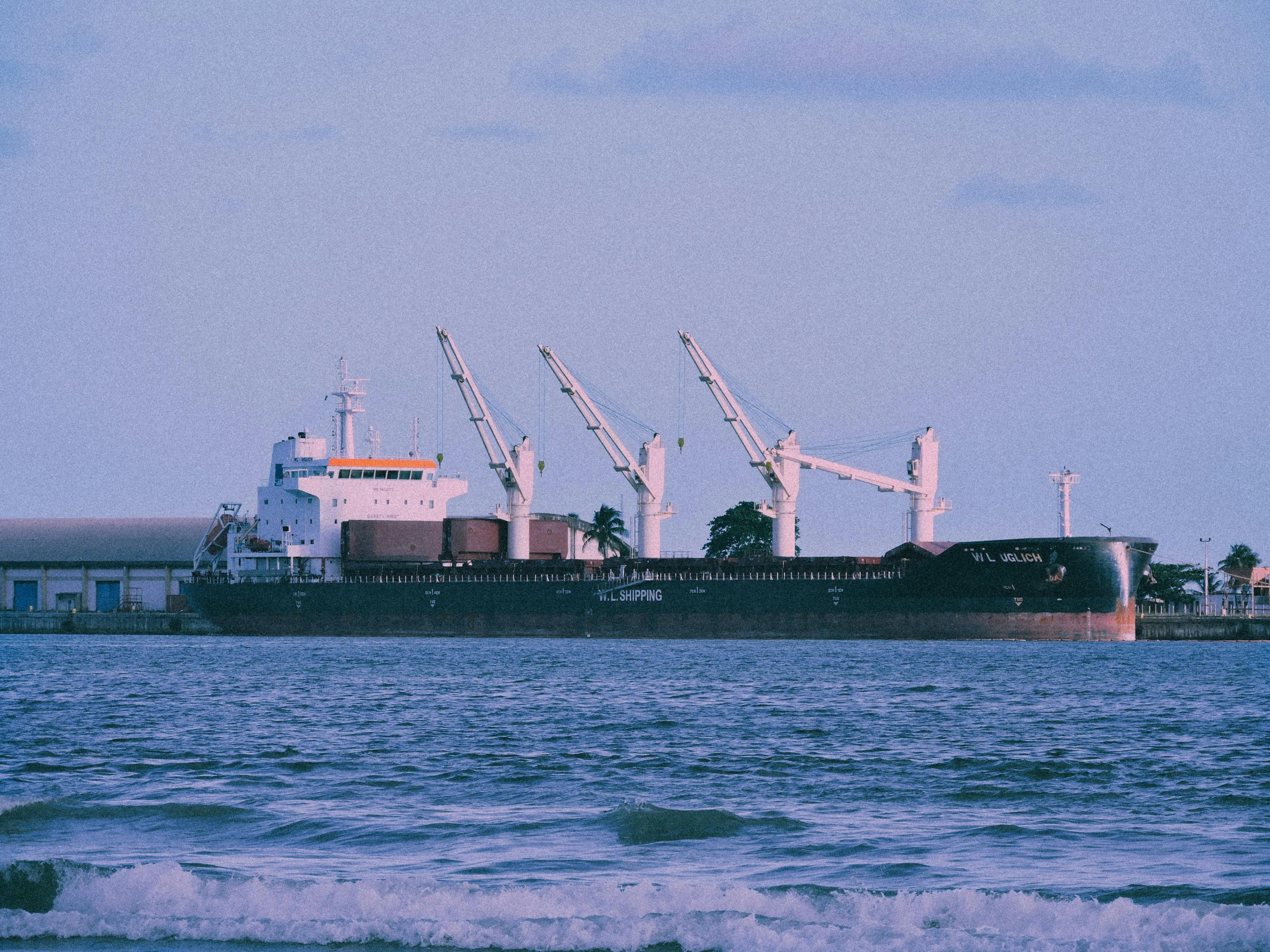 large cargo ship loaded with containers moving along the ocean