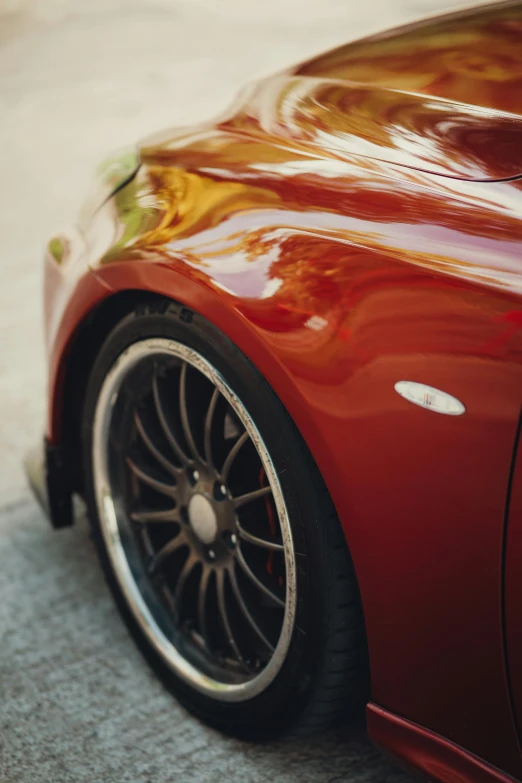 a red car has a shiny chrome rim