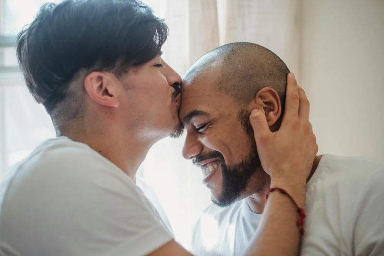 a man holding his head next to another mans face