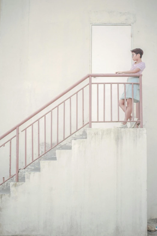 young man standing on stairway with pink railing