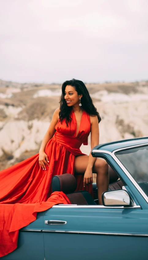 a woman in an orange dress poses for a pograph