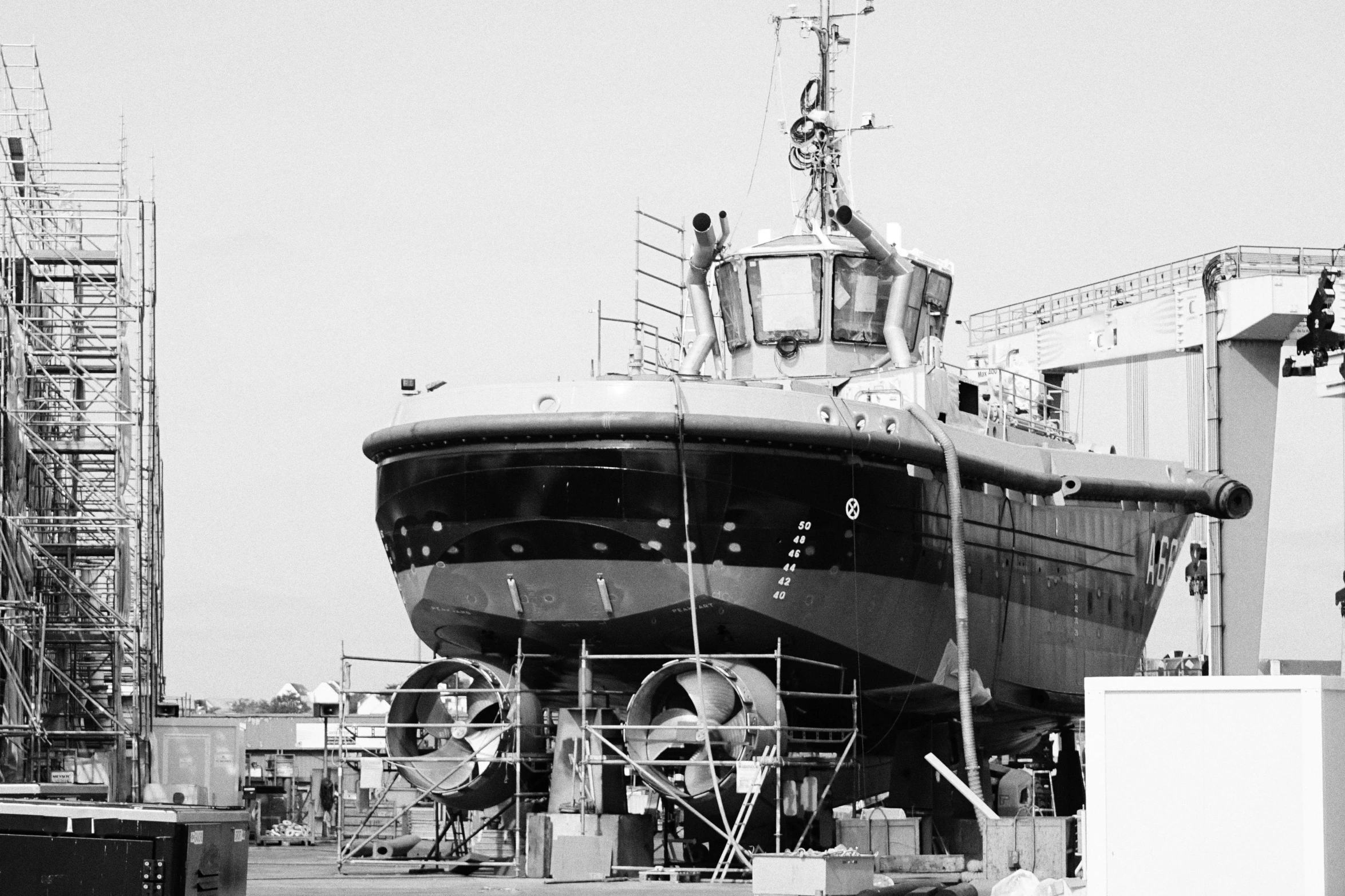 large black boat sitting on top of dry dock next to tall buildings