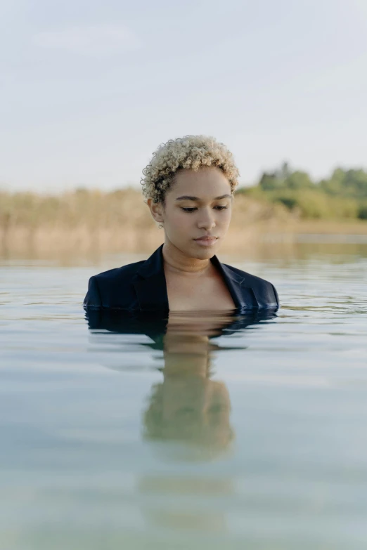 a woman in the water looks off into the distance