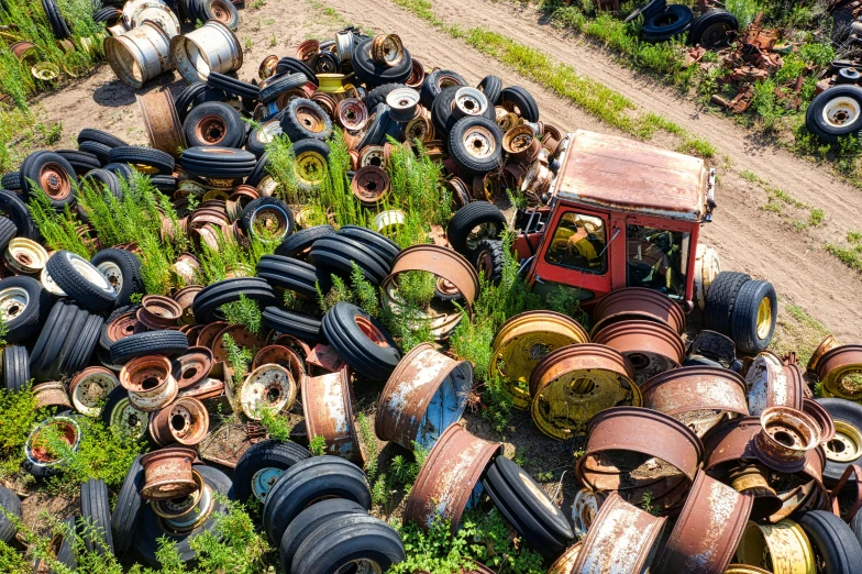 some rusty tires and tires sitting in the grass