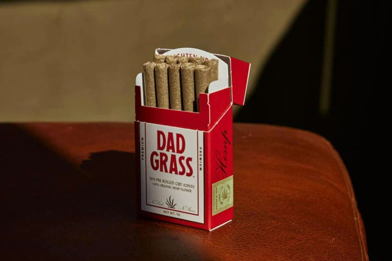 a cardboard box with cigars inside that says dad grass