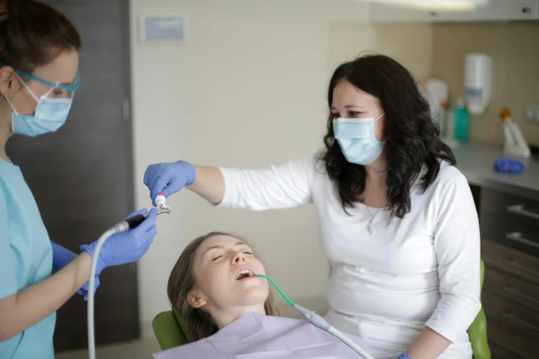 a woman getting her teeth brushed at the dentist