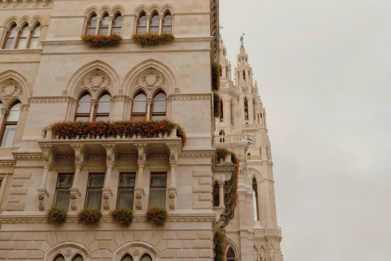 a tall building with windows and balconies with flowers