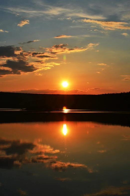 the sun is setting over a large lake with some water