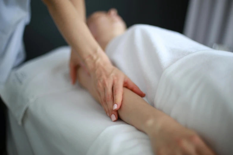 an image of someone holding their hand on the foot of a person who is in bed