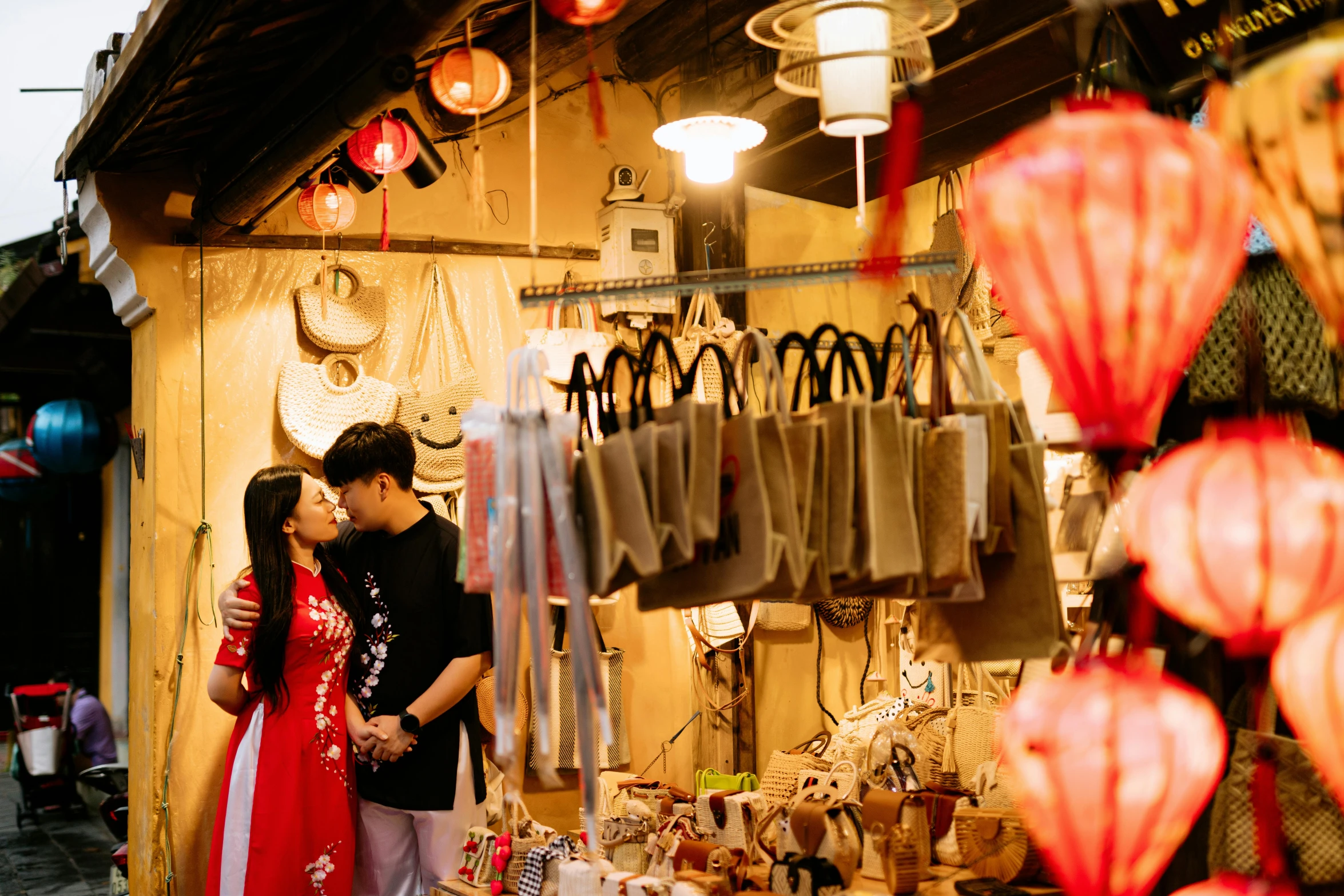 two people are emcing in front of a display of chinese lanterns