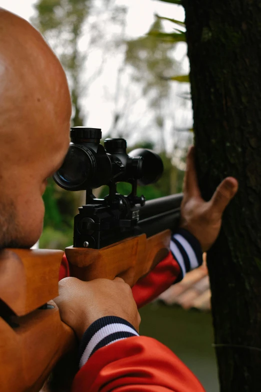 an armed man with a gun aiming a rifle