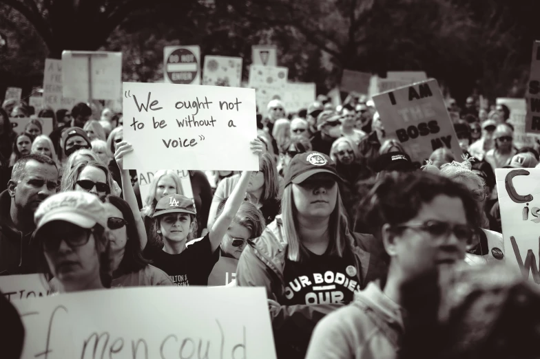 many people in the crowd holding signs and taking pictures