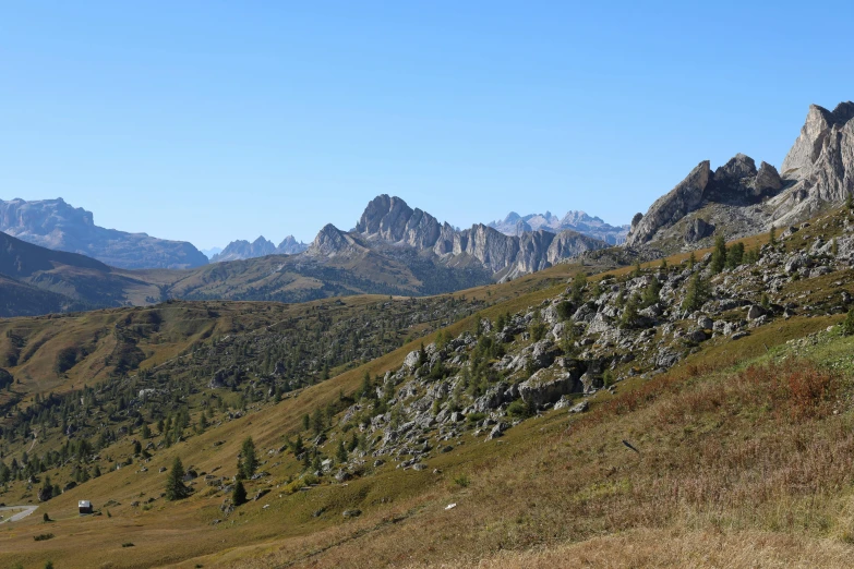 a mountain scene, taken from the ground down at a green valley