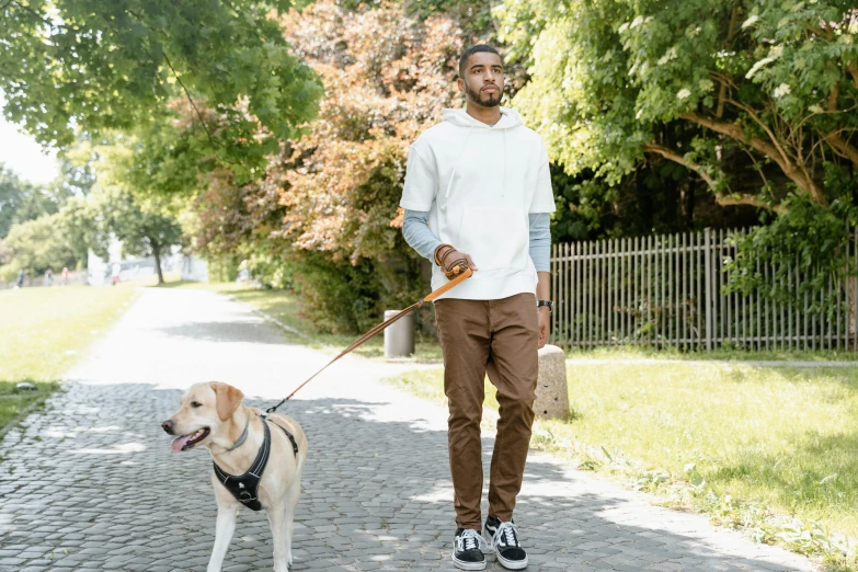 a man walking his dog while holding the leash