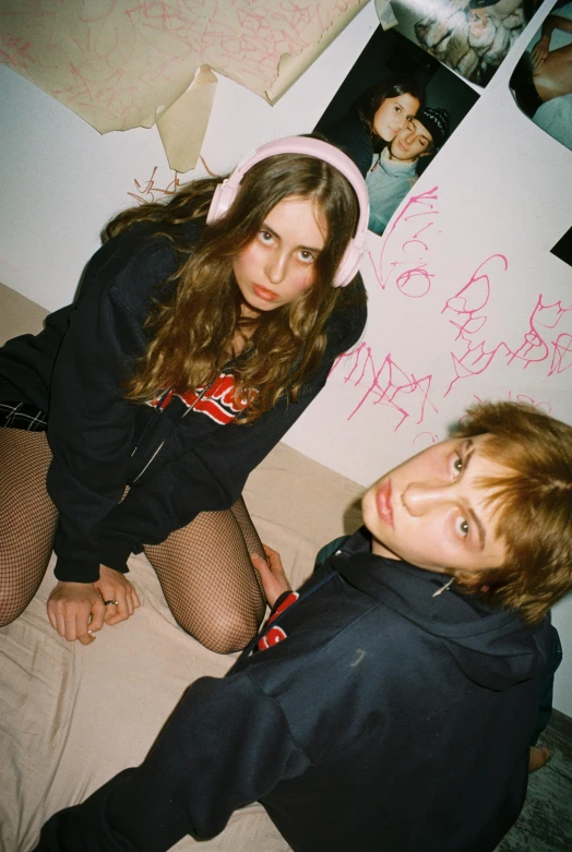 a boy and girl in black shirts in a bedroom