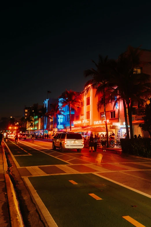 a city street with palm trees and lights on