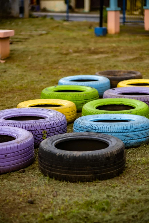 a pile of green and purple tires on top of a field