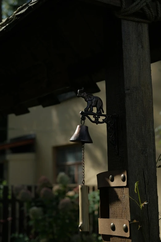 a metal cat toy on top of an outdoor bell