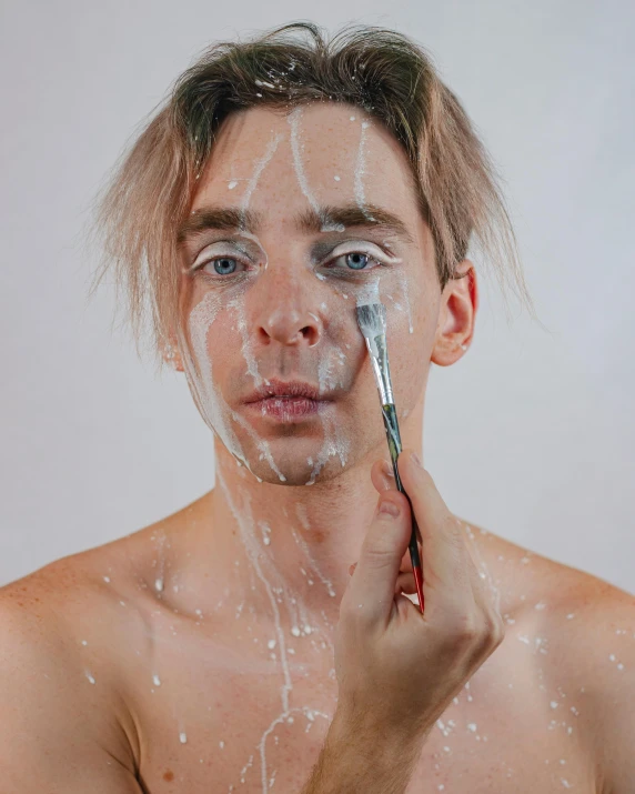 man's head showing hair, and his face with a brush on it