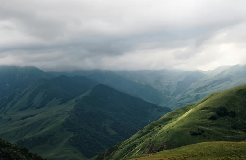 mountains with green valleys and lots of clouds