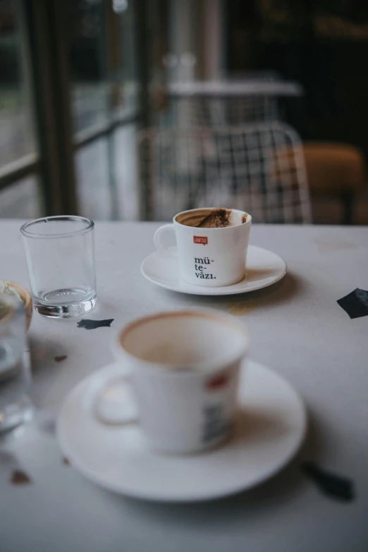 a table set for two with a small cup and saucer