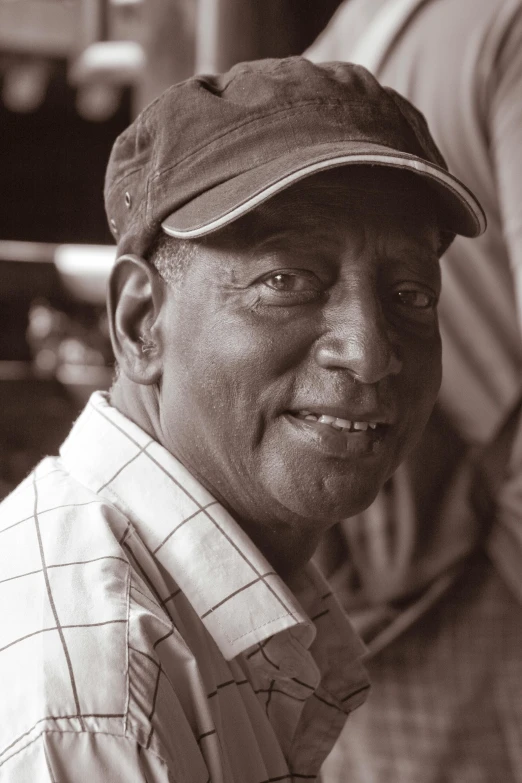 an older man in a baseball cap smiling